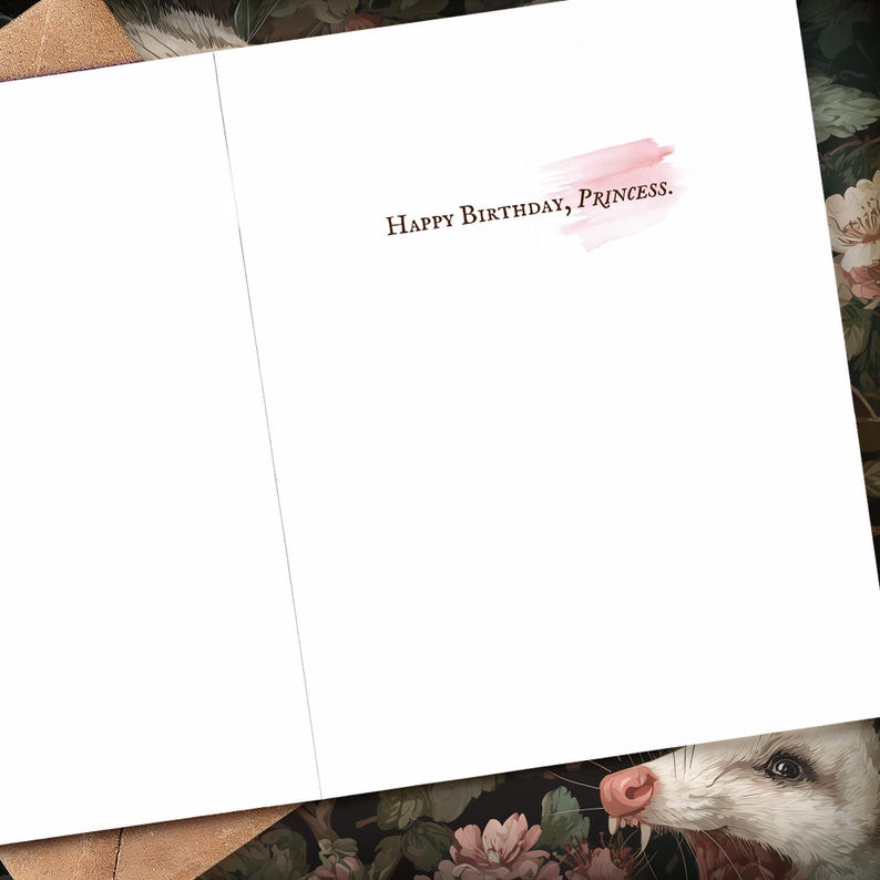 K&ouml;nnte beinhalten: Ge&ouml;ffnete wei&szlig;e Gru&szlig;karte mit dem Text "Happy Birthday, Princess" in Dunkelrosa. Hinter dem Text befindet sich ein hellrosa Aquarellpinselstrich. Die Innenseite der Karte ist leer.