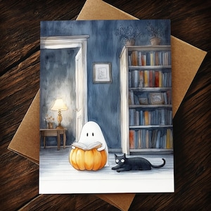 Pu&ograve; includere: Illustrazione ad acquerello di un fantasma che legge un libro su una zucca, con un gatto nero nelle vicinanze. La scena &egrave; ambientata in una stanza con una libreria, una lampada e una porta aperta. La carta &egrave; su una busta marrone.