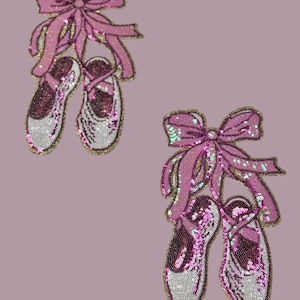 Puede incluir: Dos pares de zapatillas de ballet rosa y blancas con lazos rosas. Las zapatillas están hechas de lentejuelas y están decoradas con ribetes dorados.