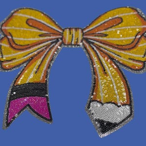 May include: A decorative bow-shaped applique with a pencil design. The bow features yellow sequins with orange and white accents. The pencil has a black, pink, and silver design, all outlined with silver beads, set against a blue background.
