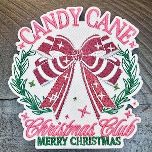 May include: Embroidered patch with a pink and white bow, green leaves, and the text "Candy Cane Christmas Club Merry Christmas".