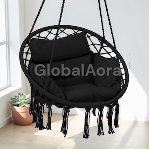 May include: Black hanging chair with a round frame and woven netting. The chair has a thick, cushioned seat and backrest, with a fringe detail at the bottom. The text "GlobalAora" is visible on the chair.