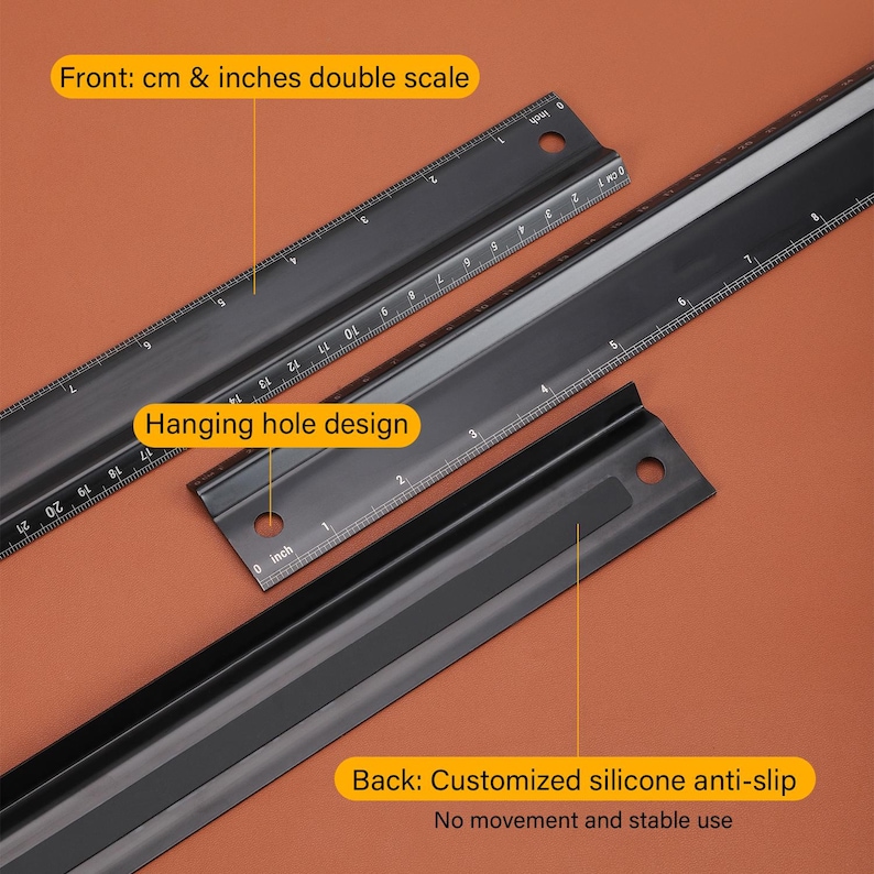 May include: Black metal ruler with a double scale in centimeters and inches. The ruler has a hanging hole design and a black silicone anti-slip back. The text on the ruler reads "Front: cm & inches double scale" and "Hanging hole design". The text on the back of the ruler reads "Back: Customized silicone anti-slip No movement and stable use".