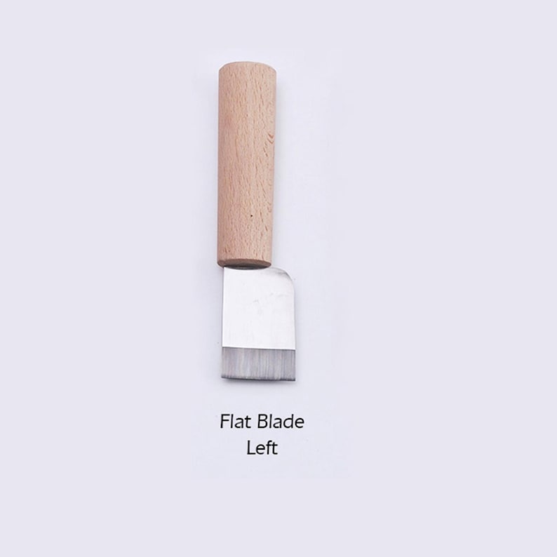 May include: A small, flat blade leather craft tool with a wooden handle. The blade is made of metal and has a slightly rounded edge. The handle is made of light brown wood. The text "Flat Blade Left" is printed below the tool.