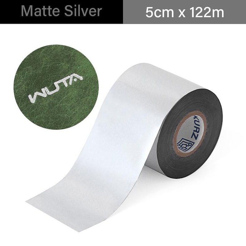 May include: Matte silver roll of foil tape, 5cm wide and 122m long. The tape is unrolled, revealing a shiny silver surface. A green circle with the word "WUTA" is in the upper left. The roll has the word "KURZ" printed on the side.