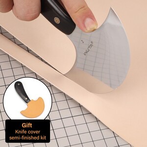 May include: A leathercraft knife with a curved blade is cutting a piece of light tan leather. The knife has a black handle and the blade is marked with the word "WUTA". A small knife cover is included in the image, with the text "Gift Knife cover semi-finished kit".