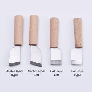 May include: Four leather craft tools with wooden handles. Two tools have a slanted blade, one with the blade angled to the right and the other to the left. The other two tools have a flat blade, one with the blade angled to the right and the other to the left.