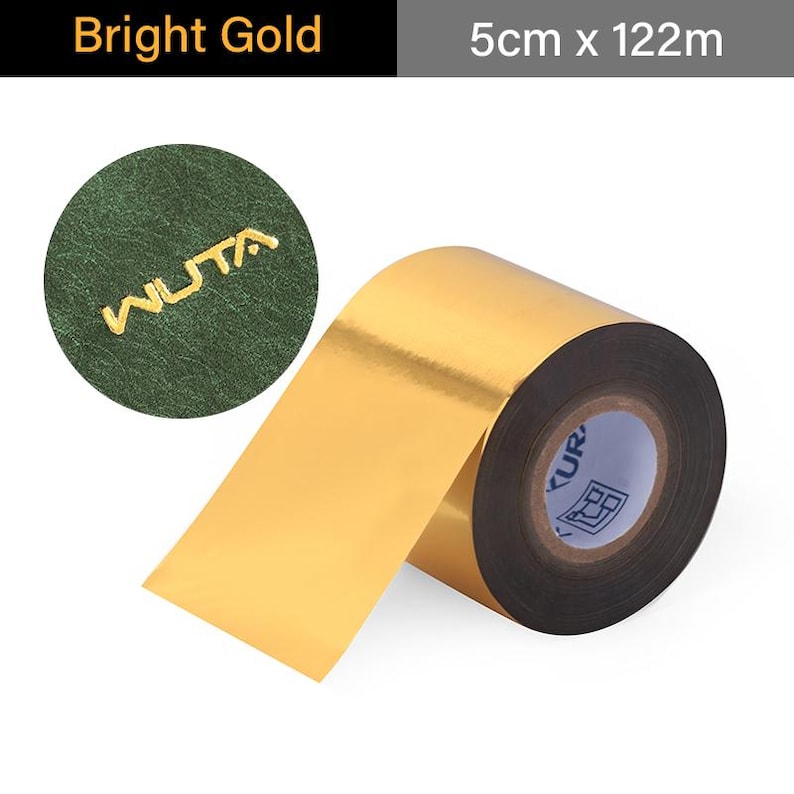 May include: A roll of bright gold foil tape, 5cm wide and 122m long, with a glossy finish. The tape is unrolled, revealing its shiny surface. A green circle with the gold text "WUTA" is in the upper left corner.