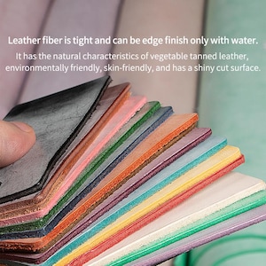 May include: A selection of colourful leather swatches are fanned out, held by a hand. The edges of the leather are visible, displaying a range of colours. Text on the image states the leather is vegetable tanned, environmentally friendly, and skin-friendly.