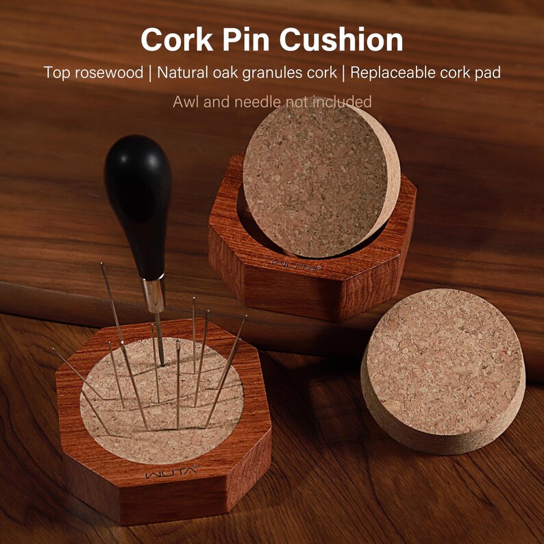 Puede incluir: Un juego de cojines de corcho con base de palisandro y almohadilla de corcho reemplazable. El juego incluye una lezna con mango negro con agujas insertadas en el corcho. El texto de la imagen dice "Cork Pin Cushion".