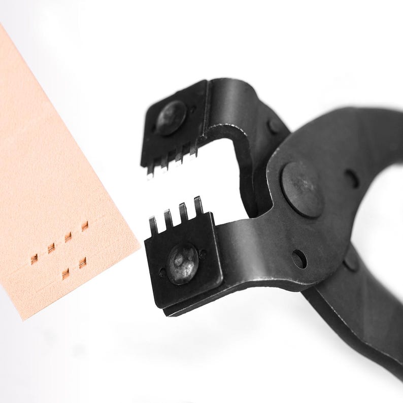 May include: Close-up of a black leather punch tool with multiple prongs, next to a piece of tan leather with punched holes. The tool is designed for creating evenly spaced holes in leather or similar materials. The background is white.