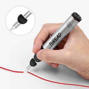 May include: A silver tool with a black tip and a red string. The tool is labeled "THREAD II by the Beadsmith".