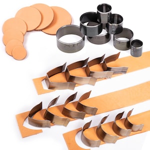 May include: A set of leather craft tools including round and curved punches, and leather scraps. The tools are made of metal and have a silver finish.