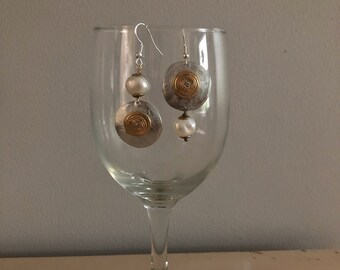 Asymmetrical hammered  aluminum button earrings with gold buttons and fresh water pearls.