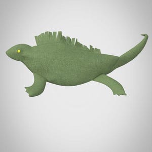 Puede incluir: Un juguete de peluche de iguana verde con una espalda espinosa y ojos amarillos.