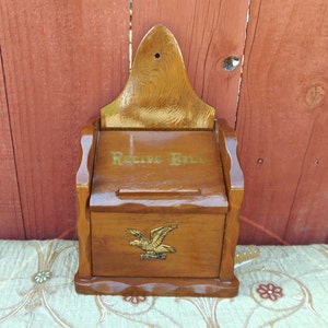 May include: A wooden recipe box with a gold eagle design and the words "Recipe File" on the front.