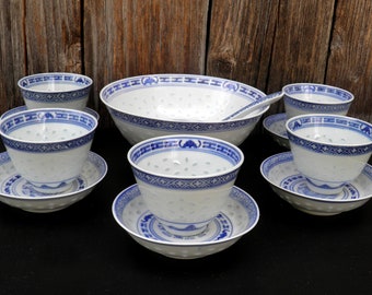May include: A set of blue and white porcelain bowls and saucers with a traditional Chinese design. The set includes a large serving bowl, six smaller bowls, and six saucers.