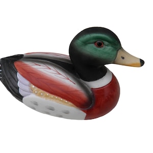 May include: A decorative wooden duck figurine. The duck has a green head, black neck, and a red and white body. The wings are black with red and white accents. The beak is yellow and the eyes are red.
