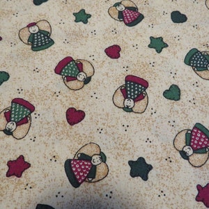 May include: Beige fabric with a repeating pattern of red and green angels, red stars, and green hearts.