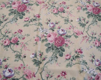 May include: Floral fabric with a cream background and a repeating pattern of pink, purple, and white roses with green leaves and stems. The roses vary in size and are scattered across the fabric.