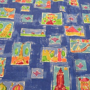 May include: Blue fabric with a repeating pattern of colorful, hand-drawn illustrations of landmarks and buildings. The illustrations are framed in rectangular boxes and include the Eiffel Tower, a lighthouse, and other architectural designs.