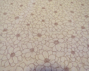 May include: A close-up of a beige fabric with a repeating pattern of brown floral designs.