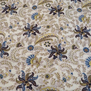 May include: A fabric featuring an off-white background with a repeating pattern of stylized dark brown and blue flowers, yellow and brown paisley-like shapes, and intricate brown leafy vines that cover the entire surface of the textile material.