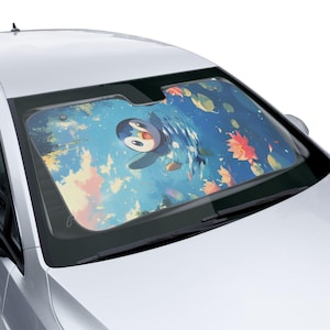 May include: Car windshield sunshade featuring a cartoon penguin swimming in a blue pond with orange and yellow flowers. The sunshade is designed to fit a car windshield and protect the interior from sunlight.
