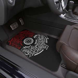 Könnte beinhalten: Schwarze Auto-Fußmatte mit einem rot-weißen geometrischen Design. Die Matte hat ein kreisförmiges Muster mit einem Netzwerk aus Linien und Formen. Die Matte ist rechteckig und passt in den Fußraum der Fahrerseite eines Autos.