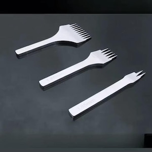 May include: Three silver leathercraft tools with different prong configurations. Each tool has a handle and a head with evenly spaced prongs. The tools are labeled with "3.85mm".