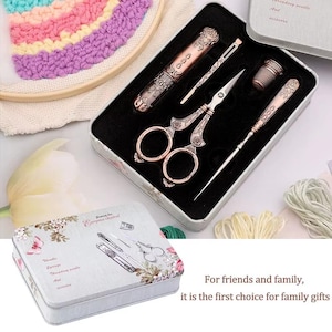 May include: A sewing kit in a rectangular metal tin featuring floral illustrations and the text Sewing for European classical. Inside, a black foam insert holds a pair of ornate copper-toned scissors, a needle case, a thimble, and an awl.