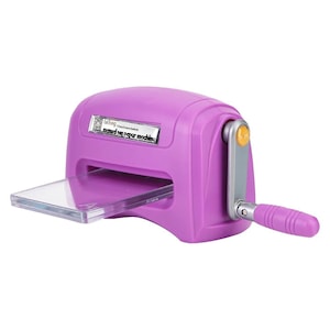 Peut inclure: Une machine à découper manuelle violette avec une manivelle argentée dotée d'une poignée violette. Une plaque en plastique transparent marquée de la lettre A est insérée dans la fente avant. Une étiquette argentée affiche LeTong manual die paper machine.