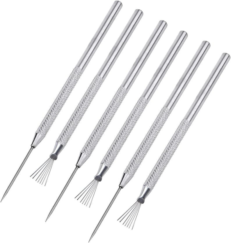 May include: Set of six silver-colored metal coil cleaning tools. Each tool has a textured handle and a thin, pointed end with a fan-shaped brush. The tools are designed for cleaning air conditioner coils and other similar applications.