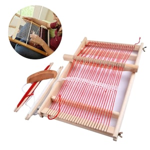 May include: A wooden loom with red yarn strung across it. The loom is made of natural wood and has a comb for weaving.
