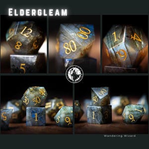 Puede incluir: Un conjunto de dados de piedras preciosas con n&uacute;meros dorados. Los dados son de varias formas y tama&ntilde;os, con una mezcla de tonos azules, verdes y marrones. La palabra "ELDERGLEAM" est&aacute; en la parte superior y "Wandering Wizard" en la parte inferior.