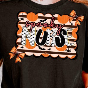 May include: Black t-shirt with a Halloween-themed graphic. The design features the words "spooky NURSE" in a playful font, surrounded by pumpkins, bats, spiders, and decorative bows. The design is in orange, black, and white.