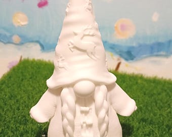 May include: A white ceramic gnome figurine with a pointed hat and braided pigtails. The hat is decorated with embossed deer and floral designs. The gnome wears a coat with a buttoned closure.
