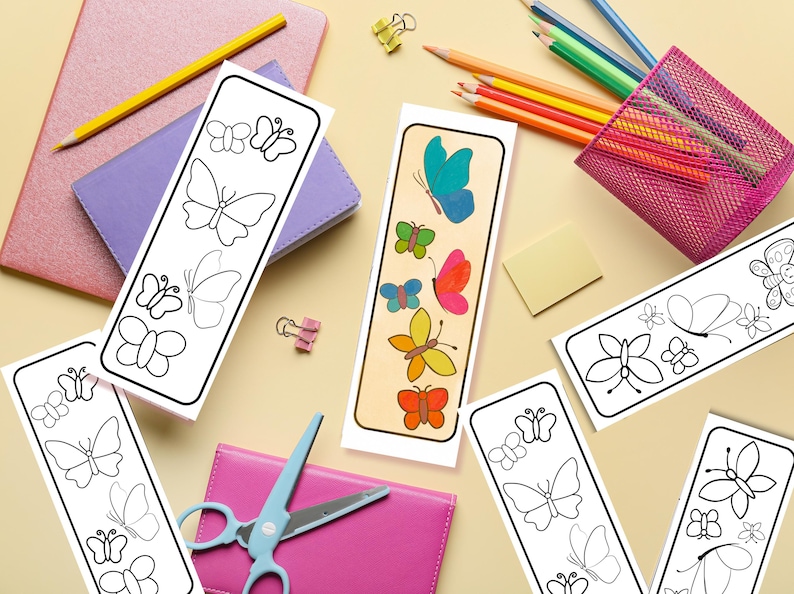 May include: A collection of butterfly-themed bookmarks. Some bookmarks feature black and white butterfly outlines, while others showcase colorful butterfly illustrations. Pencils, notebooks, and scissors are also visible, suggesting a school or craft theme.