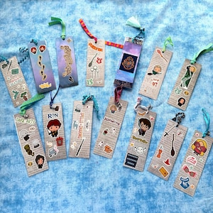 May include: A collection of handmade bookmarks with various designs and text. Each bookmark features a different theme, including characters, symbols, and quotes. They are made of paper and have colorful ribbons attached.