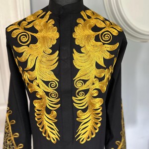 May include: A black long-sleeved shirt with a mandarin collar and intricate gold embroidery on the front and cuffs.