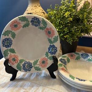 May include: A white ceramic mug with a black handle and the text "But First, Coffee" in a black, bold font. The mug is on a white surface.