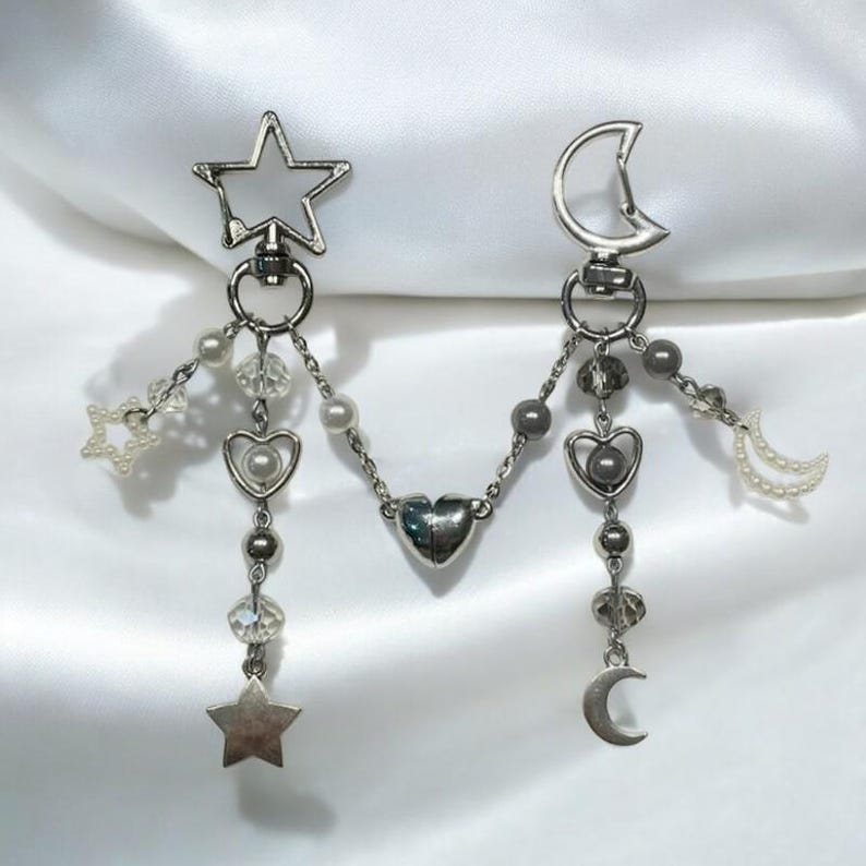 Pu&ograve; includere: Un braccialetto con ciondoli in argento a forma di stella, luna e cuore. I ciondoli sono attaccati a una catena d'argento con piccole perline. Il braccialetto &egrave; perfetto per aggiungere un tocco di fantasia a qualsiasi outfit.