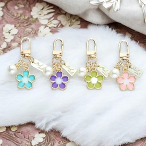 Chaveiro de pérolas Sakura flor de cerejeira | Etiqueta de letras feminina | Decoração de bolsa para fone de ouvido