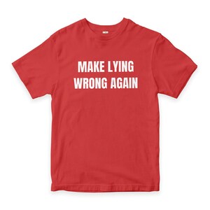 Może przedstawiać: Czerwona koszulka z białym napisem "MAKE LYING WRONG AGAIN" wydrukowanym z przodu. Koszulka jest w jednolitym czerwonym kolorze i wydaje się być wykonana z miękkiego materiału.