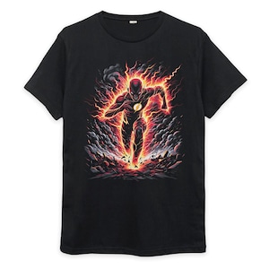 Może przedstawiać: Czarny t-shirt z krótkim rękawem z nadrukiem graficznym przedstawiającym biegnącą postać otoczoną żywymi pomarańczowymi i czerwonymi efektami błyskawic, dymem oraz odłamkami. Postać ma na sobie ciemny kostium z żółtym emblematem błyskawicy na piersi.