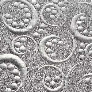 Peut inclure: Gros plan sur un tissu argenté texturé avec un motif en relief. Le motif présente des formes en spirale et en volutes avec des perles. Le tissu a un éclat métallique subtil, créant une texture visuellement attrayante.