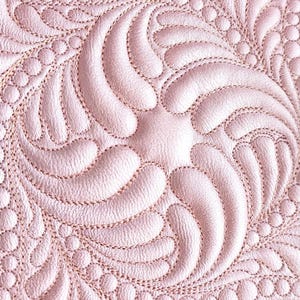 May include: A light pink material featuring an intricate quilted pattern of swirling, feather-like shapes and rows of small, raised circular dots. The surface has a subtle metallic sheen and a textured finish created by detailed machine stitching.
