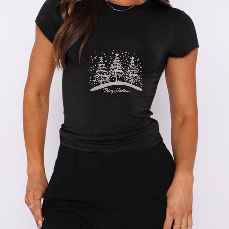 May include: Black t-shirt with a white design of three Christmas trees and the text "Merry Christmas".