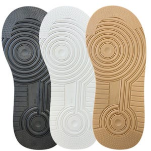 May include: Three rubber shoe soles in black, white, and tan. Each sole features a circular pivot point pattern at the forefoot and heel, a textured toe and heel area, and the size 38-40 embossed in the centre of the arch.