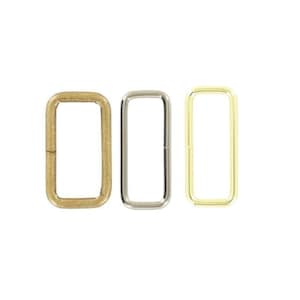 May include: Three rectangular metal loops arranged side by side. The first loop on the left has a matte antique brass finish, the middle loop has a polished silver-tone finish, and the third loop on the right has a bright polished gold-tone finish.
